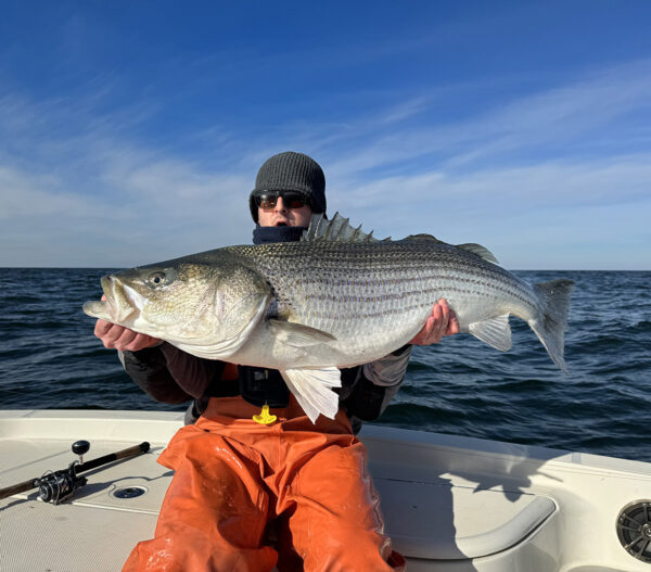 ایک کشتی پر ایک بڑے باس کو پکڑے ہوئے ایک آدمی کی تصویر